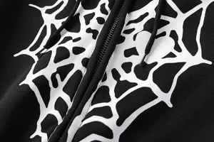 Détail de sweat à capuche noir avec un imprimé graphique de toile d'araignée blanche et molleton.