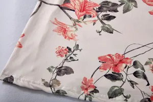 Close-up view of the floral print fabric and fine stitching detail on the dress hem.