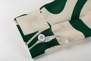 Vue détaillée du poignet de chemise à manches longues avec imprimé abstrait vert et blanc.
