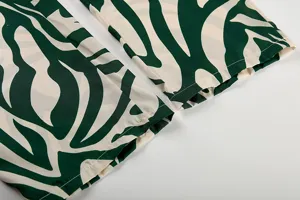 Détail de manchette de pantalon imprimé de feuilles, style streetwear décontracté, tissu fin.