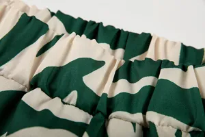 Détail de la taille élastique du pantalon à imprimé abstrait vert et beige, tissu doux.