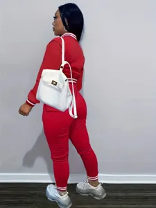 Completo tuta sportiva rosso casual con giacca e pantaloni con dettagli a righe.