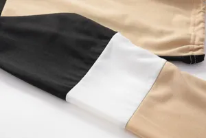 Detailopname van de kleurblokmouw op de damestop met lange mouwen, nette stiksels.