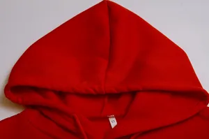 Close-up detail of red hoodie hood, featuring soft fleece material, adjustable drawstring, and tag.