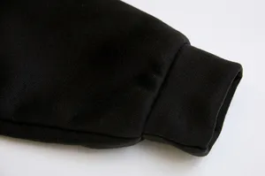 Black fleece sweatshirt sleeve cuff detail shot, comfortable winter apparel design view.