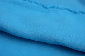 Close-up detail of soft blue fleece sweatshirt fabric, showing texture and neat stitching.