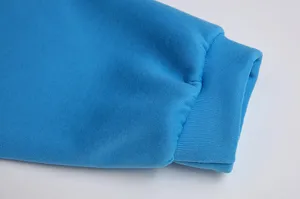 Detailed close-up view of blue fleece hoodie sleeve cuff, soft texture winter apparel.