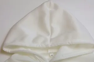 White fleece lined hoodie detail shot featuring adjustable drawstring hood and inner size label.