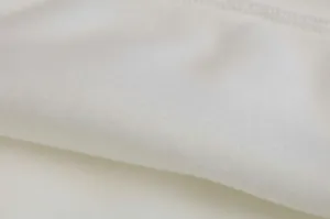 Detailed close-up of soft white fleece fabric showing texture and stitching quality.