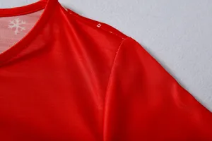 Nahraufnahme des roten Weihnachtskleidungsstücks mit weißem Schneeflocken-Muster.