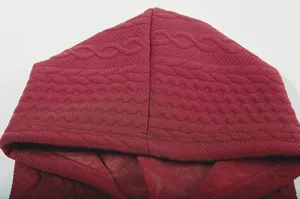 Detailed close-up shot of the wine red jacquard textured hoodie fabric, showing premium quality.