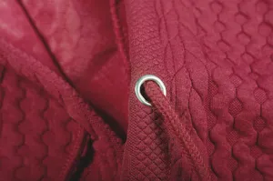 Detailed view of women's burgundy jacquard hoodie fabric, metal eyelet and drawstring.