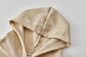 Λεπτομέρεια από μπεζ φούτερ κουκούλα με fleece επένδυση, απαλή υφή, προσεγμένες ραφές.