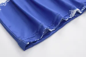 Close-up detail of the blue printed fabric hem and fine stitching of the fashion maxi dress.