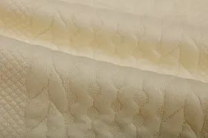 Close up view of premium light yellow jacquard fabric with delicate geometric pattern texture.
