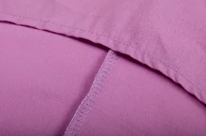 Close-up van de stiksels en fijne afwerkingsdetails van de paarse katoenen en linnen stoffen.