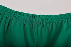 Detailopname van de elastische tailleband van een groene casual broek van katoenmix stof