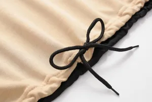 Detailopname van stijlvolle sweatshirt met trekkoord en contrasterende kleuren.