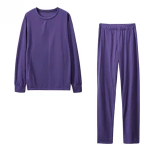 Dettaglio top a maniche lunghe e pantaloni viola, tessuto tinta unita e design pulito.