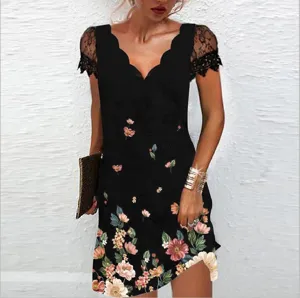 Detail robe noire a fleurs avec col V festonne et manches courtes en dentelle.