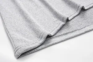Close-up detail of grey knitted fabric texture, soft material, neat stitching, premium quality.