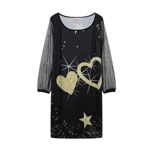 Vista detallada del vestido negro de manga larga de malla con corazones dorados.