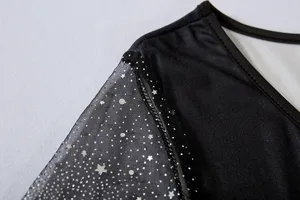 Primer plano detallado del vestido de mujer de malla transparente con lentejuelas de estrella.