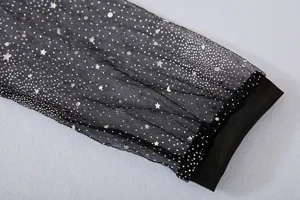 Primer plano de la manga de malla negra transparente con estrellas y luna de purpurina.