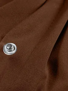 Brown jacket fabric detail with metal snap button close-up view showing clothing texture.
