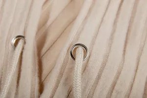 Beige ribbed knit hoodie detail close-up showing fabric texture metal eyelets and drawstrings