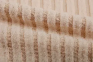Close-up of beige ribbed knit fabric with soft texture and cozy winter feel for apparel.