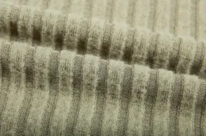Close-up detail shot of soft ribbed knitted fabric texture with cozy vertical stripe pattern.