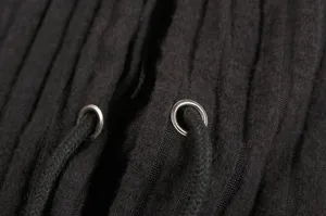 Black ribbed knit hoodie detail close up featuring metal eyelets and adjustable drawstrings.