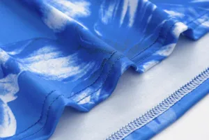 Blue floral print dress fabric detail showing fine stitching and smooth material texture.