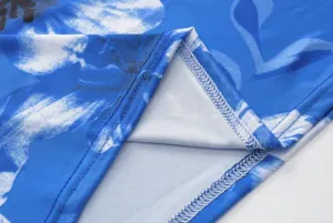 Close-up detail of blue floral print fabric showing neat edge stitching and soft textile texture.
