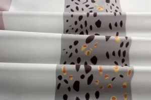 Nahaufnahme des Stoffes mit gestreiftem Muster und abstrakter Tierprint-Textur für Bekleidung.
