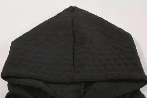 Detail view of the black jacquard hooded sweatshirt showing textured fabric and hood design.
