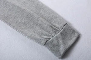 Grey long sleeve top cuff detail, showing soft knitted fabric texture and neat stitching.