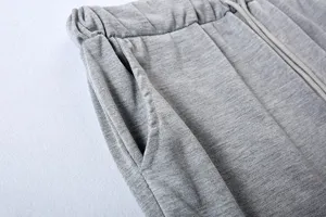 Grey casual sweatpants detail shot featuring elastic drawstring waistband and side pockets.