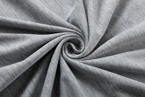 Close-up detail shot of soft gray fabric featuring elegant swirl draping texture.