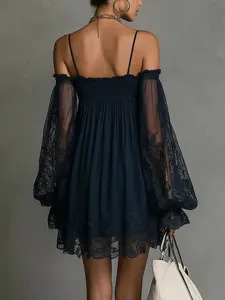 Detalle de vestido de encaje transparente de manga larga azul marino con hombros descubiertos.