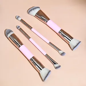 Vista detallada de brochas de maquillaje rosas de doble punta con virolas doradas y cerdas.