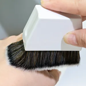 Detaillierte Nahaufnahme eines professionellen Make-up-Pinsels mit weichen, gewellten Borsten.