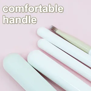Gedetailleerd uitzicht op witte make-up penseel handvat, zachte ergonomische grip.