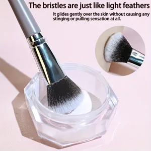 Makeup brush detail shot showing ultra-soft dual-color bristles dipping into a clear jar.