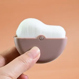 Portable makeup brush with white bristles and brown shell for blending foundation.