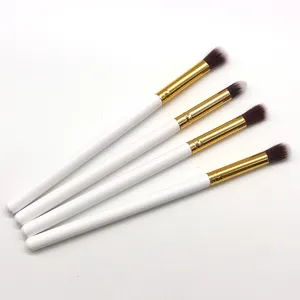 Detail view of a 4-piece small eyeshadow brush set with white handles and golden ferrules.