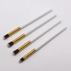 Close up of small eyeshadow brush details, white handle with gold ferrule and soft bristles.