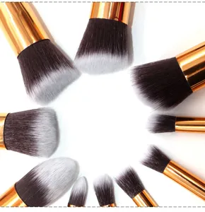 Set of 10 makeup brushes with golden handles and soft black white gradient bristles.