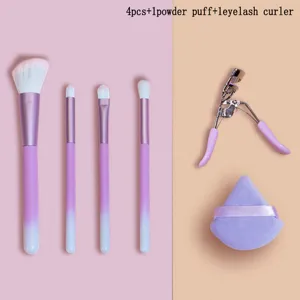 Detailed view of makeup brush set including powder puff and eyelash curler tools.